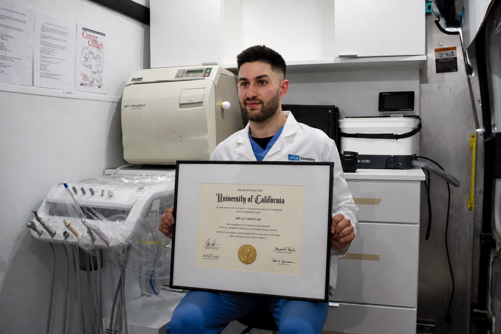 Dr. Milad Gheisari holding his Doctor of Dental Surgery degree from the University of California