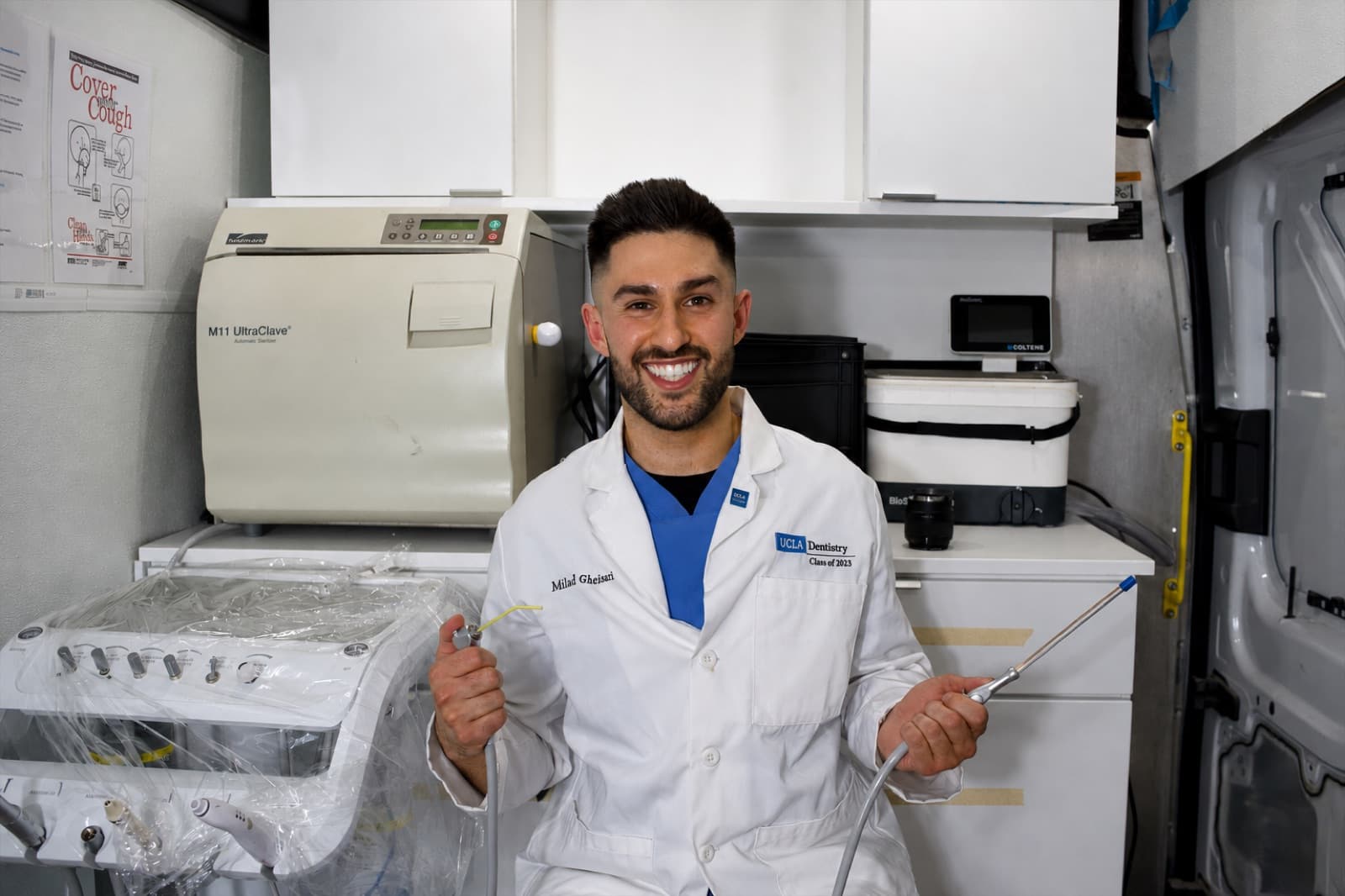Dr. Milad Gheisari, lead dentist at Las Vegas Mobile Dental Clinic, holding dental instruments inside the mobile dental van